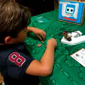 Benjamin montando um barco do kit robottime